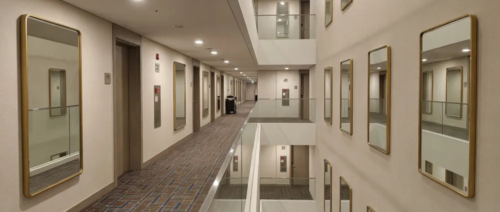 Hotel corridor with consistent hallway mirror installations across multiple floors