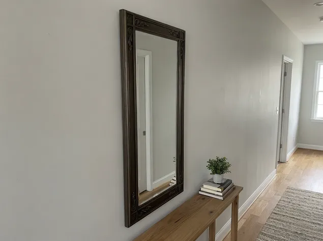 Narrow vertical hallway mirror with decorative accent frame