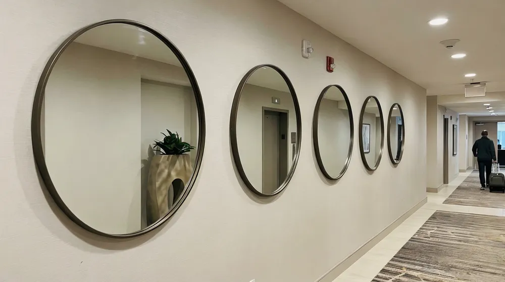 Round accent mirrors installed in hotel lobby corridor