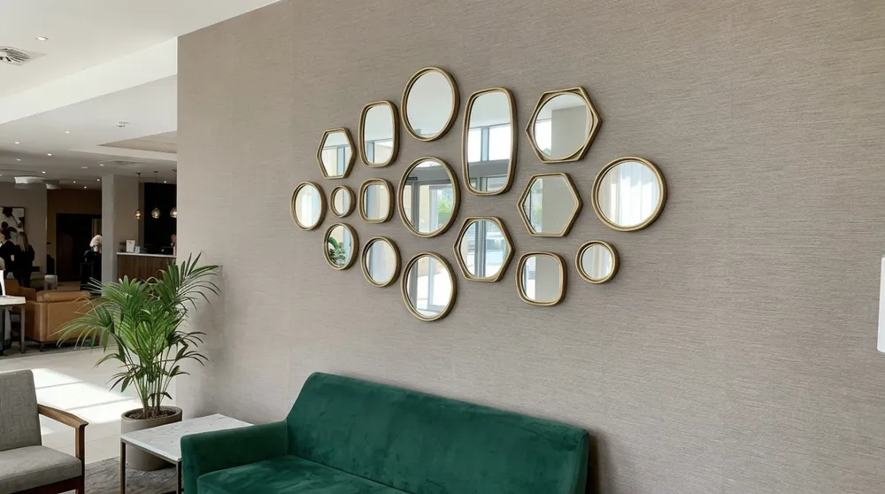 Grouped small mirrors arranged on hotel lobby feature wall